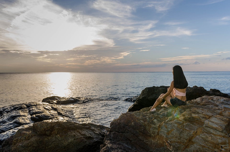 נערה יושבת מול הים
